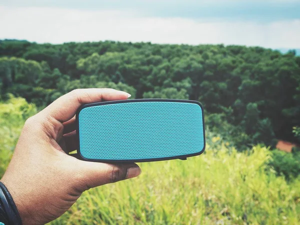 bluetooth hoparlör açık havada tutan kadın görüntüsünü kırpılmış