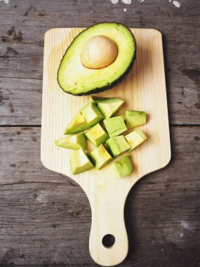 Doğrama Kurulu üzerinde ahşap arka plan üzerinde taze avokado dilimlenmiş