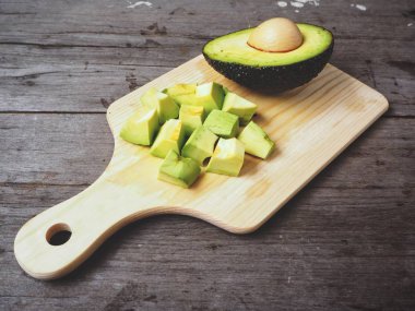 Doğrama Kurulu üzerinde ahşap arka plan üzerinde taze avokado dilimlenmiş