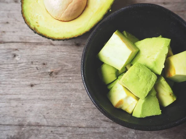 Avocado Fresco Tritato Ciotola Nera Sfondo Legno — Foto Stock