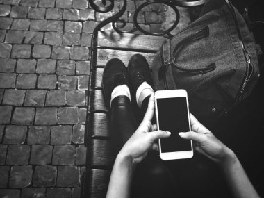 Çanta ile akıllı telefon kullanan kadın