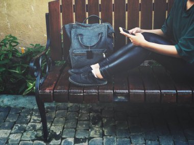 Çanta ile akıllı telefon kullanan kadın