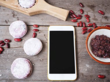 Ahşap arka plan üstünde smartphone ile geleneksel festival Çin moon kek