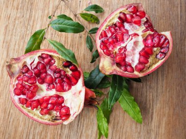 Ahşap zemin üzerine yeşil yaprakları ile taze Olgun kırmızı nar