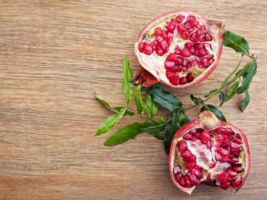 Ahşap zemin üzerine yeşil yaprakları ile taze Olgun kırmızı nar