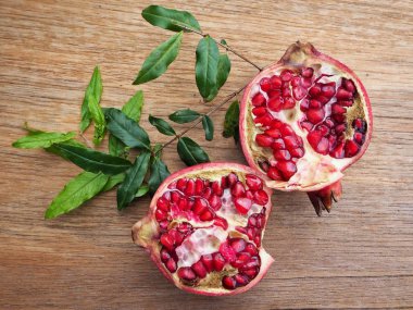 Ahşap zemin üzerine yeşil yaprakları ile taze Olgun kırmızı nar