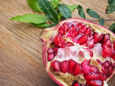 Ahşap zemin üzerine yeşil yaprakları ile taze Olgun kırmızı nar