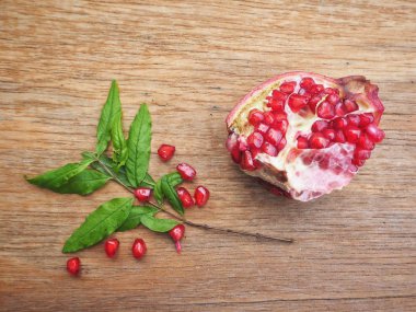 Ahşap zemin üzerine yeşil yaprakları ile taze Olgun kırmızı nar