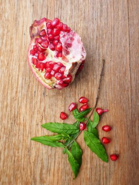 Ahşap zemin üzerine yeşil yaprakları ile taze Olgun kırmızı nar
