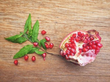 Ahşap zemin üzerine yeşil yaprakları ile taze Olgun kırmızı nar