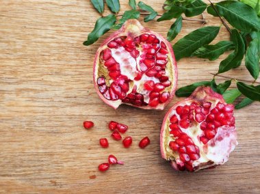 Ahşap zemin üzerine yeşil yaprakları ile taze Olgun kırmızı nar