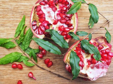 Ahşap zemin üzerine yeşil yaprakları ile taze Olgun kırmızı nar