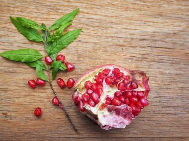 Ahşap zemin üzerine yeşil yaprakları ile taze Olgun kırmızı nar