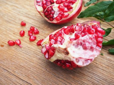 Ahşap zemin üzerine yeşil yaprakları ile taze Olgun kırmızı nar