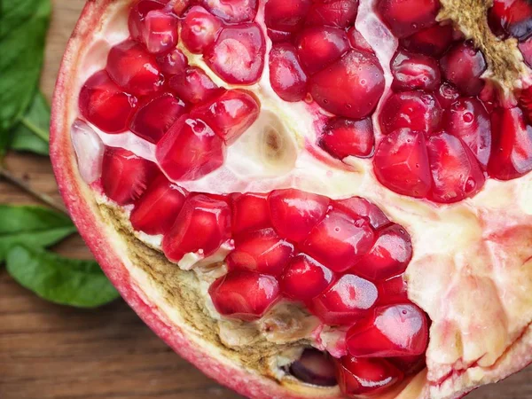 Ahşap zemin üzerine yeşil yaprakları ile taze Olgun kırmızı nar