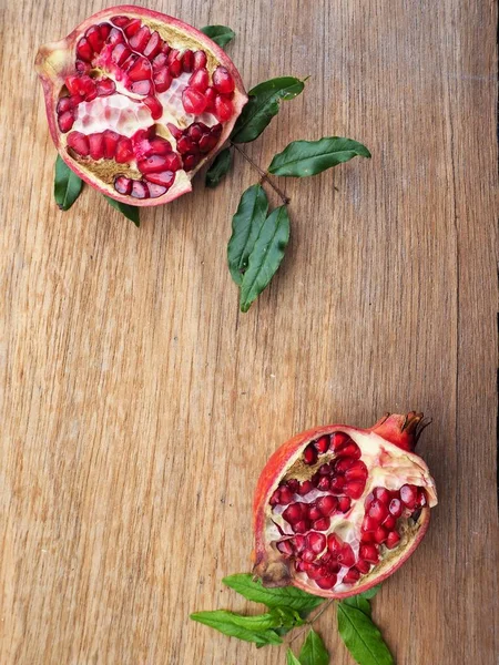 Ahşap zemin üzerine yeşil yaprakları ile taze Olgun kırmızı nar