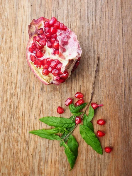 Ahşap zemin üzerine yeşil yaprakları ile taze Olgun kırmızı nar