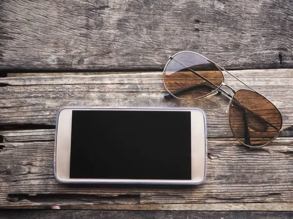 Смартфон з сонячними окулярами — стокове фото