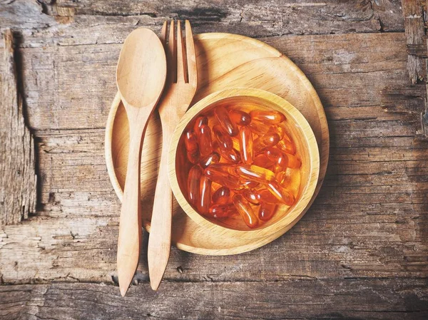 Cápsulas de aceite de hígado de bacalao con tenedor y cuchara —  Fotos de Stock