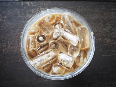 ahşap masa üzerinde plastik kap lezzetli buzlu kahve üstten görünüm