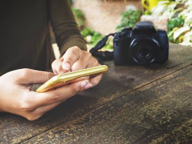 Fotoğraf makinesi ile akıllı telefon kullanan kadın görünümü Kapat