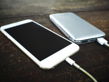 Smartphone ile güç kıyısında ahşap masa