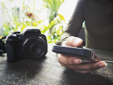 Fotoğraf makinesi ile akıllı telefon kullanan kadın görünümü Kapat