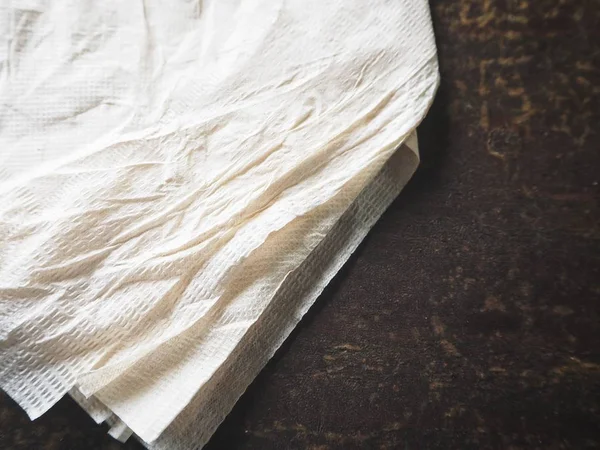 Pile of rumpled paper napkins on wooden background