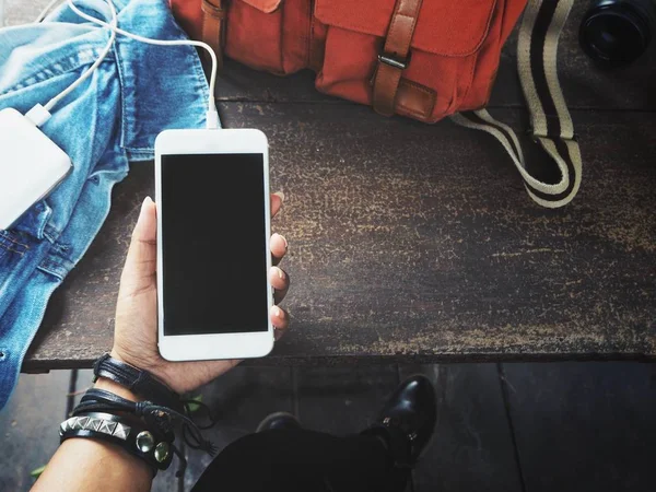 Ahşap masa üzerinde güç banka ile akıllı telefon kullanan kadın