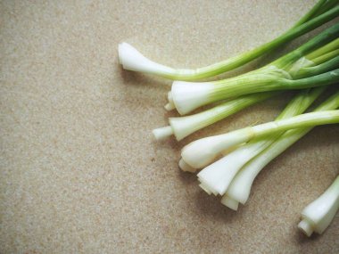 Kahverengi taş zemin üzerine taze yeşil soğan