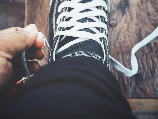 Cropped Shot Person Tying Shoelaces Sneaker Wooden Surface — Stock Photo, Image