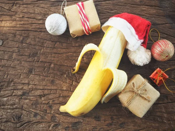 Banan Boże Narodzenie Kapelusz Dekoracjami Podłoże Drewniane — Zdjęcie stockowe