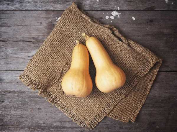 Olgun sarı butternut squashes çul eski ahşap zemin üzerine 