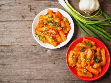 Ahşap arka plan üzerinde taze soğan ile geleneksel Kore yemeği pirinç keki servis