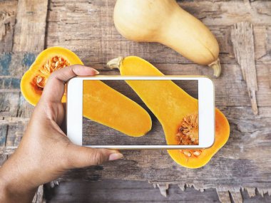butternut squashes smartphone ile fotoğraf çekici kişinin kırpılmış atış 