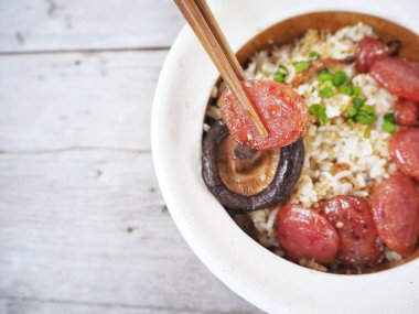 Geleneksel Çin yemeği kızarmış pilav sosis ve mantar ahşap arka plan üzerinde