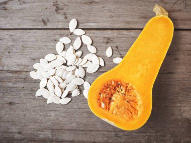 ahşap masa üzerinde taze olgun yarıya kabak ve tohum üstten görünüm  