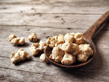 Ahşap zemin üzerine kaşıkla vegan gıda için soya protein yığını