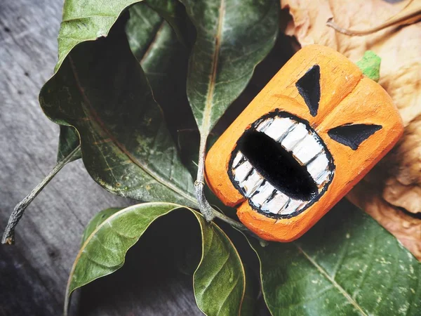 Halloween pumpkin with scary face on wooden background