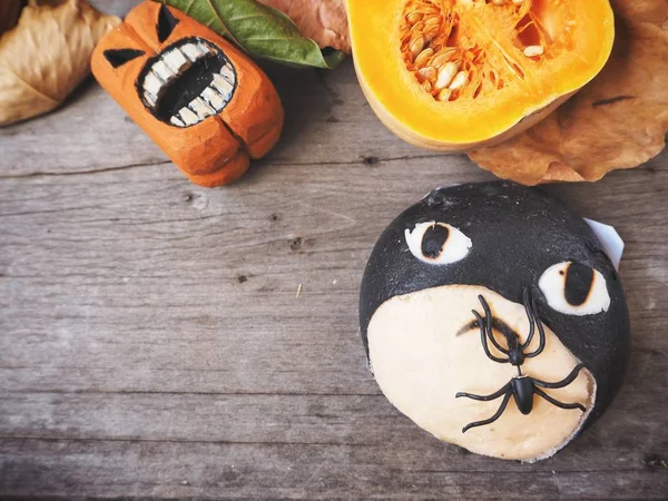 Halloween bread with pumpkins on wooden background