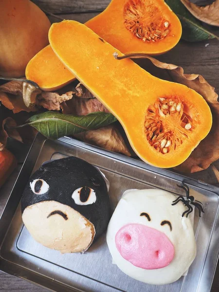 Halloween breads with pumpkins on wooden background