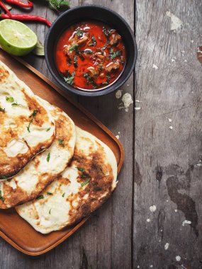 Ahşap arka plan üzerinde Hint naan ekmek ile baharatlı körili çorba servis