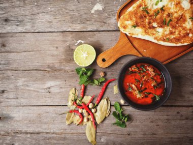 Ahşap arka plan üzerinde Hint naan ekmek ile baharatlı körili çorba servis