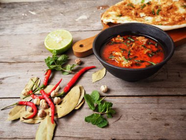 Ahşap arka plan üzerinde Hint naan ekmek ile baharatlı körili çorba servis