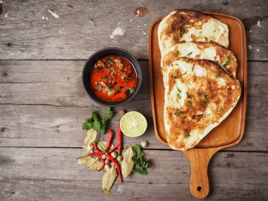 Ahşap arka plan üzerinde Hint naan ekmek ile baharatlı körili çorba servis
