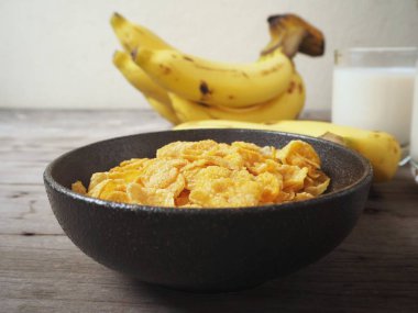 Mısır gevreği ahşap arka plan üzerinde muz ile servis görünümü Kapat