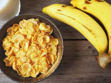 Mısır gevreği ahşap arka plan üzerinde muz ile servis görünümü Kapat