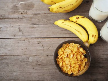 Mısır gevreği süt ve muz ahşap arka plan üzerinde üstten görünüm