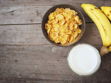 Mısır gevreği süt ve muz ahşap arka plan üzerinde üstten görünüm