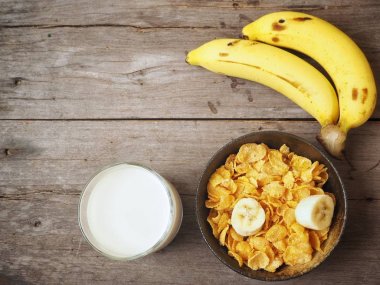 Mısır gevreği süt ve muz ahşap arka plan üzerinde üstten görünüm